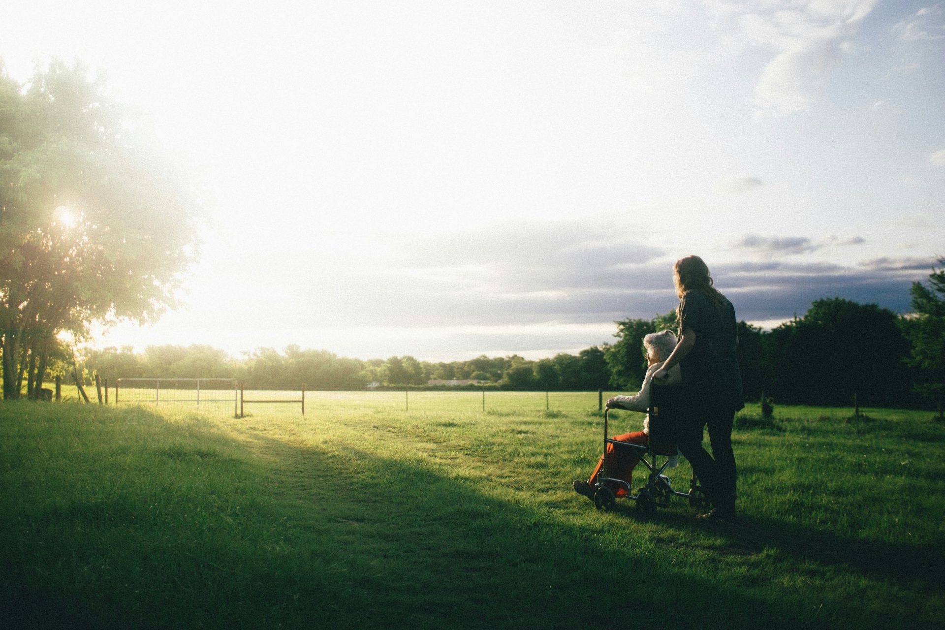 woman standing next to woman riding wheelchair